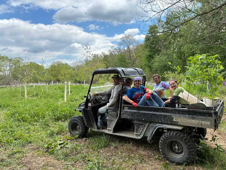 Dickinson College Farm electric jitney transporting tools and trees to the Wittlinger Preserve project site.